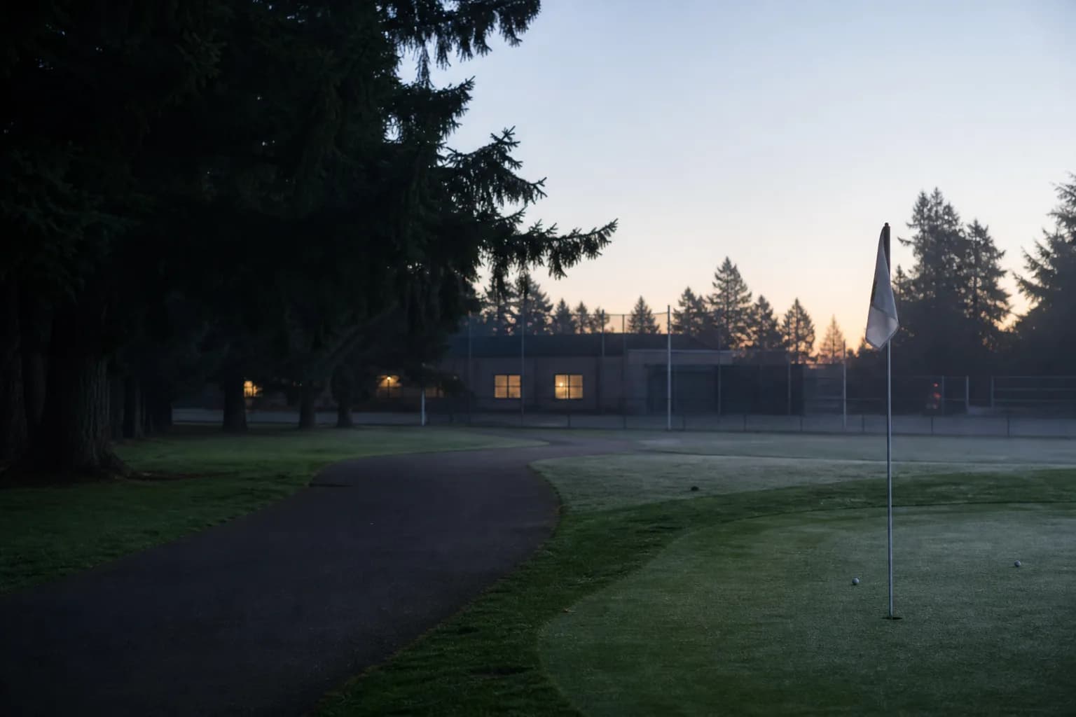 A quiet campus golf practice green in early morning light.